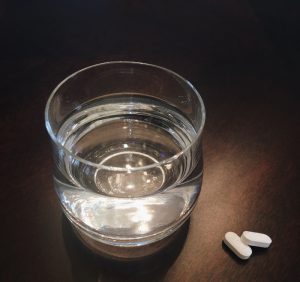 頭痛薬とコップに入った水